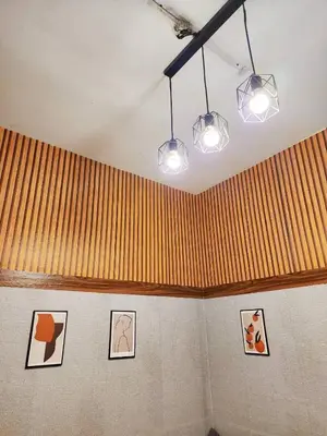 a room with three pictures on the wall and lights at 109 Homely Apartment Free Wi-Fi Near BTS in Bangkok