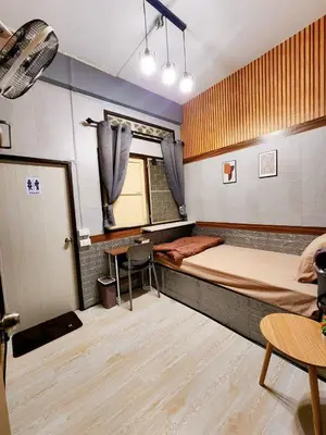 a room with two beds and a table and a door at 109 Homely Apartment Free Wi-Fi Near BTS in Bangkok