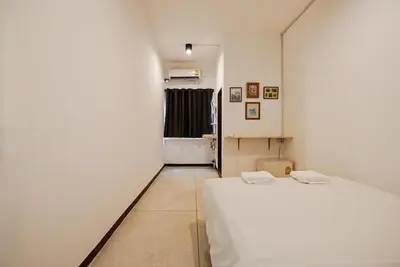 a bedroom with a white bed and a window at XX GO INN Asiatique Charoen krung V โกอินน์ เอเซียทีค เจริญกรุง in Bangkok