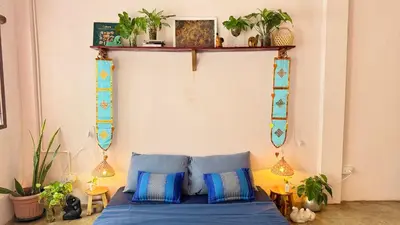 a bedroom with a blue bed with plants on the wall at Baan YentaFo - Pink House 2nd floor in Chinatown