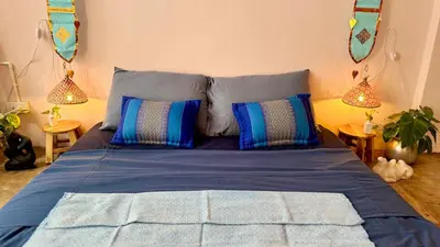a blue bed with blue pillows in a bedroom at Baan YentaFo - Pink House 2nd floor in Chinatown