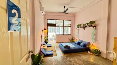 a living room with a blue couch in a room at Baan YentaFo - Pink House 2nd floor in Chinatown