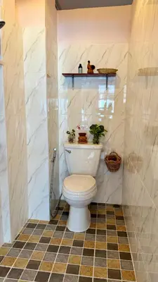 a bathroom with a toilet with plants on a shelf at Baan YentaFo - Pink House 2nd floor in Chinatown