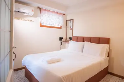 a bedroom with a large bed with white sheets at JB Home Bangkok - Victory monument in Bangkok