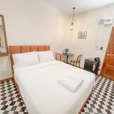 a bedroom with a large white bed and a table at JB Home Bangkok - Victory monument in Bangkok