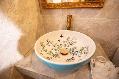 a sink with flowers painted on it in a bathroom at JB Home Bangkok - Victory monument in Bangkok