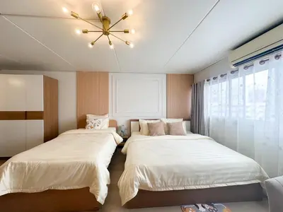 a bedroom with two beds and a ceiling fan at NK hostel 18 in Thung Si Kan