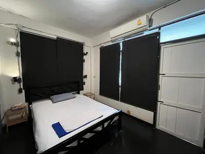 a bedroom with a bed with two large windows at silom Dream catcher rainbow hostel in Bangkok
