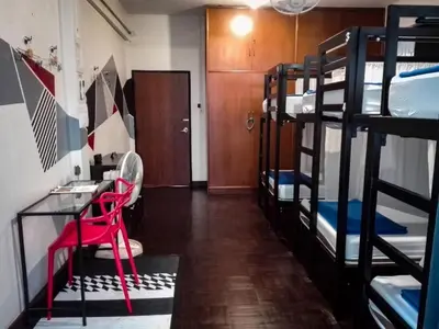 a room with bunk beds with a desk and a table at silom Dream catcher rainbow hostel in Bangkok