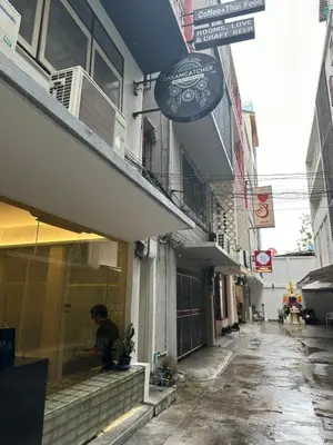 a man sitting in a window of a building at silom Dream catcher rainbow hostel in Bangkok