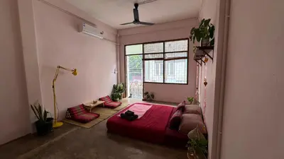a bedroom with a red bed and a window at Baan YentaFo - Pink House 3rd floor in Chinatown