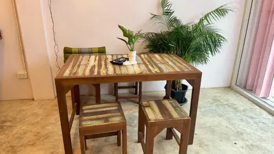 a wooden table with two chairs and a table with plants at Baan YentaFo - Pink House 3rd floor in Chinatown