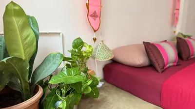 a living room with a red bed and a plant at Baan YentaFo - Pink House 3rd floor in Chinatown