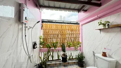 a bathroom with a toilet and a window with plants at Baan YentaFo - Pink House 4th floor in Chinatown