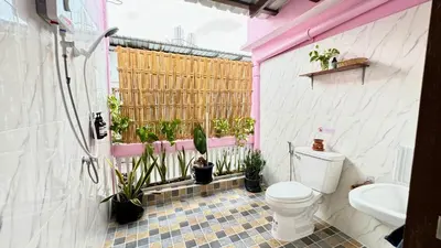 a bathroom with a toilet and potted plants in it at Baan YentaFo - Pink House 4th floor in Chinatown