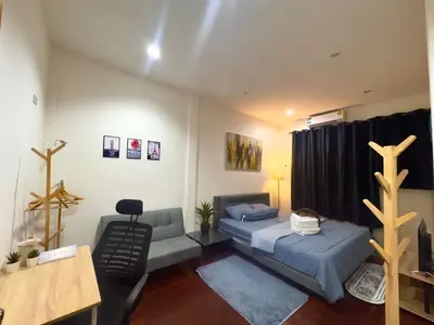 a bedroom with two beds and a desk and a table at Twenty One Place in Bangkok