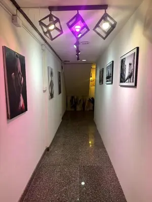 a hallway with a purple light and pictures on the walls at Twenty One Place in Bangkok