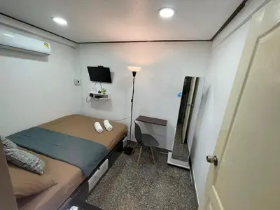 a small bedroom with a bed and a television at Twenty One Place in Bangkok