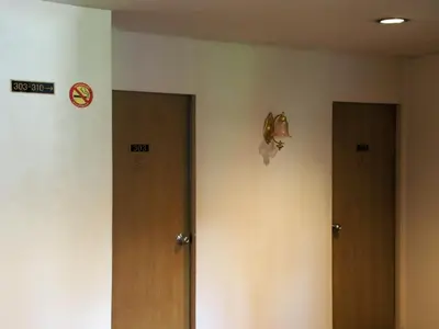 three doors in a room with a sign on the wall at XX Wish Inn Chidlom V วิช อินน์ ชิดลม 2 in Bangkok