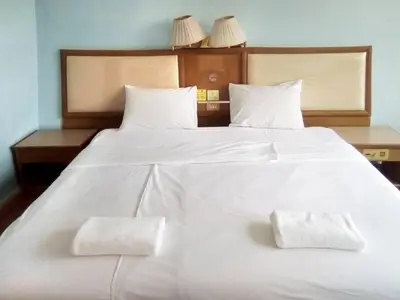 a large white bed with two white towels on it at XX Wish Inn Chidlom V วิช อินน์ ชิดลม 2 in Bangkok