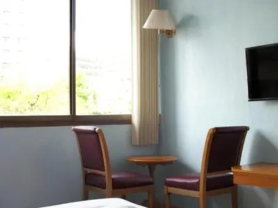 a room with two chairs and a table and a window at XX Wish Inn Chidlom V วิช อินน์ ชิดลม 2 in Bangkok