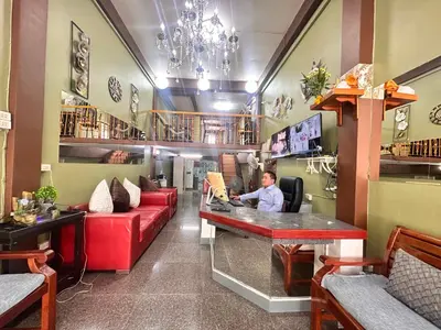 a man sitting at a bar in a restaurant at Yuma Tashi Hostel in Bangkok