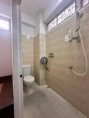 a bathroom with a toilet and a shower at Yuma Tashi Hostel in Bangkok