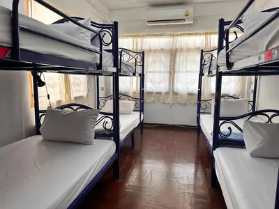 a room with three bunk beds in a room at Yuma Tashi Hostel in Bangkok
