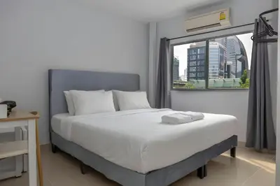 a bedroom with a large bed and a window at Elite Hotel Nana Sukhumvit 3 in Bangkok