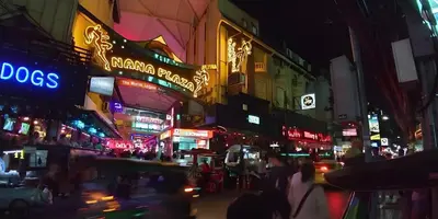 a busy city street at night with neon signs at Elite Hotel Nana Sukhumvit 3 in Bangkok