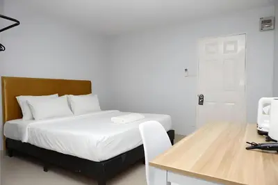 a bedroom with a bed and a desk with a computer at Elite Hotel Nana Sukhumvit 3 in Bangkok
