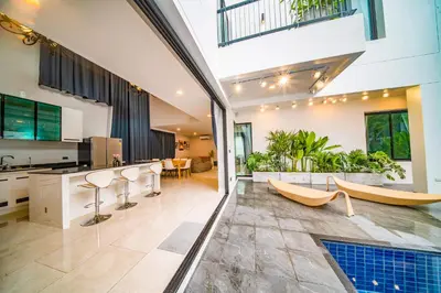 an open kitchen and living room with a pool in a house at 943summer villa曼谷中心Asok&Tong lor800平海天别墅 in Bangkok