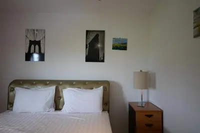 a bedroom with a bed with three pictures on the wall at Arttra Villa in Bang Chak