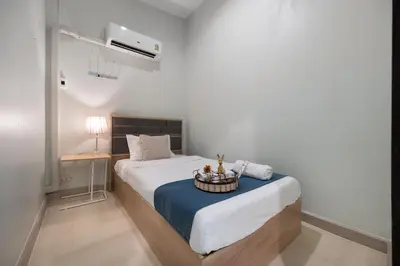 a bedroom with a white bed with a blue table at 4BR house MRT subway 250m Chatujak Market wi-fi in Bangkok