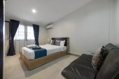 a bedroom with a bed and a couch at 4BR house MRT subway 250m Chatujak Market wi-fi in Bangkok