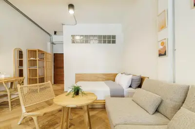 a living room with a bed and a table at Wabisabi Bangkok 3 MIN To Train Station in Bangkok