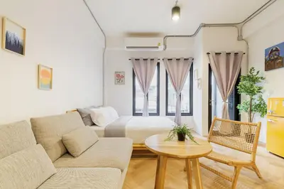 a living room with a bed and a couch and a table at Wabisabi Bangkok 3 MIN To Train Station in Bangkok