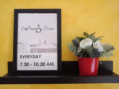 a picture on a shelf with a vase of flowers at Your Place Hotel in Bangkok