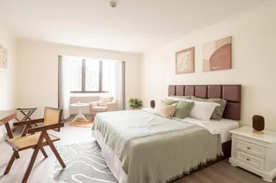 a white bedroom with a large bed and a desk at BUA Suite Sukhumvit, Nana BTS in Bangkok