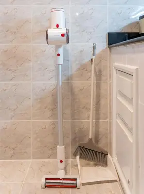 a mop and broom in the corner of a bathroom at BUA Suite Sukhumvit, Nana BTS in Bangkok