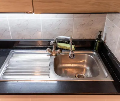 a sink with a faucet in a kitchen at BUA Suite Sukhumvit, Nana BTS in Bangkok