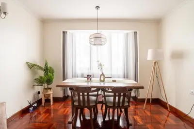 a dining room with a table and chairs and a window at BUA Suite Sukhumvit, Nana BTS in Bangkok