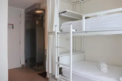 a room with two bunk beds and a hallway at ResT Bangkok Poshtel in Bangkok