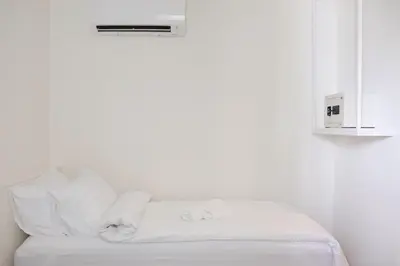 a white room with a white couch with towels on it at ResT Bangkok Poshtel in Bangkok
