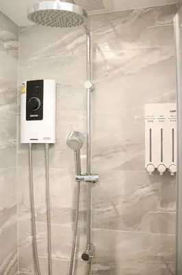 a shower with a shower head in a bathroom at ResT Bangkok Poshtel in Bangkok