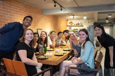 a group of people sitting at a table in a restaurant at BED STATION Hostel Ratchthewi in Bangkok