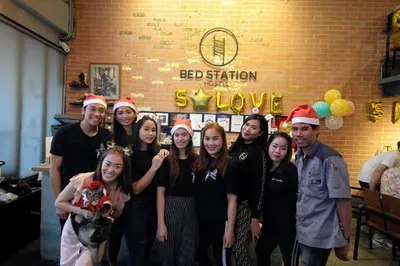 a group of people wearing christmas hats posing for a picture at BED STATION Hostel Ratchthewi in Bangkok