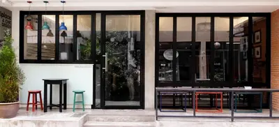 a store front with tables and stools in front of it at DI Place in Bangkok