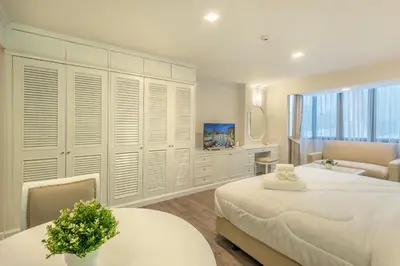 a bedroom with two beds and a large window at Neom Town Residence in Bangkok