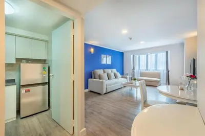 a kitchen and living room with a couch and a table at Neom Town Residence in Bangkok